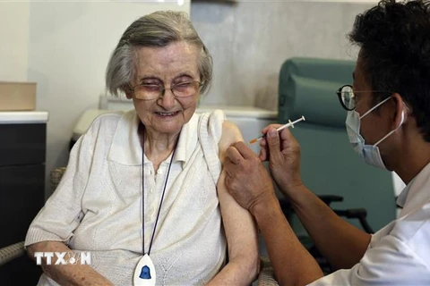 Nhân viên y tế tiêm vaccine ngừa COVID-19 cho người dân tại Paris, Pháp. (Ảnh: AFP/TTXVN) 