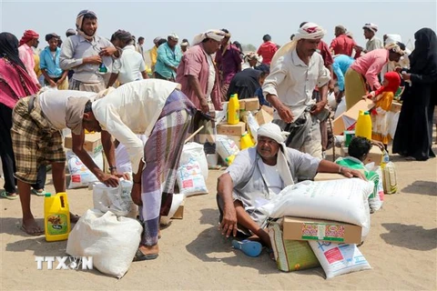 Người dân nhận hàng cứu trợ tại một trại tị nạn ở thành phố Hodeidah, Yemen ngày 31/8/2022. (Ảnh: AFP/TTXVN) 