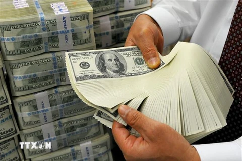 Nhân viên kiểm đồng USD tại ngân hàng ở Seoul, Hàn Quốc. (Ảnh: AFP/TTXVN) 