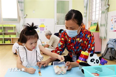 Giáo viên trường Mầm non Sơn Ca 14, quận Phú Nhuận, Thành phố Hồ Chí Minh dạy trẻ nhận biết đồ vật. (Ảnh: Hồng Đạt/TTXVN) 