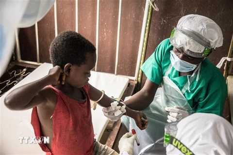 Nhân viên y tế lấy mẫu máu xét nghiệm cho em bé tiếp xúc với bệnh nhân mắc đậu mùa khỉ tại Zomea Kaka, Cộng hòa Trung Phi. (Ảnh: AFP/TTXVN)