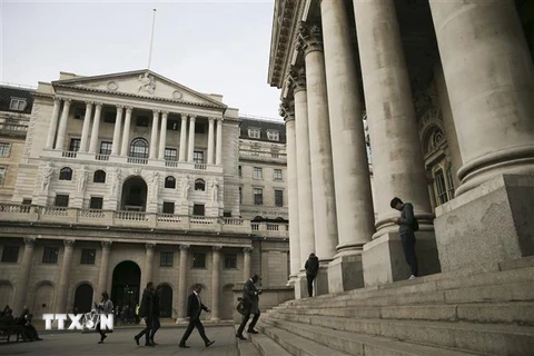 Quang cảnh bên ngoài trụ sở Ngân hàng Trung ương Anh (bên trái) ở London. (Ảnh: AFP/TTXVN) 