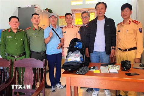 Cán bộ, chiến sỹ Phòng Cảnh sát Giao thông, Công an tỉnh Hà Giang và Công an xã Minh Tân (huyện Vị Xuyên) tiến hành trao trả lại tài sản cho ông Choi Kiyoung. (Ảnh: TTXVN phát) 