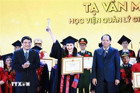 Chủ nhiệm Ủy ban Văn hóa, Giáo dục của Quốc hội Nguyễn Đắc Vinh trao tặng bằng khen cho các thủ khoa. (Ảnh: Minh Đức/TTXVN)