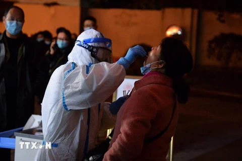 Nhân viên y tế lấy mẫu xét nghiệm COVID-19 cho người dân tại Thành Đô, thủ phủ tỉnh Tứ Xuyên, Trung Quốc. (Ảnh: AFP/TTXVN) 