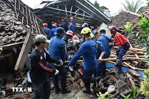 Lực lượng cứu hộ nỗ lực giải cứu người mắc kẹt dưới đống đổ nát vì động đất tại thị trấn Cianjur, tỉnh Tây Java, Indonesia, ngày 23/11/2022. (Ảnh: AFP/TTXVN) 