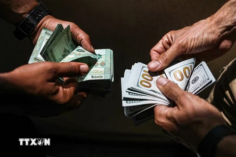 Người dân đổi tiền bảng Liban và tiền USD tại Beirut, Liban. (Ảnh: AFP/TTXVN)