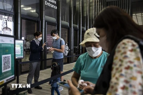 Người dân trình thẻ tiêm vaccine ngừa COVID-19 trước khi vào viện bảo tàng ở Hong Kong, Trung Quốc, ngày 21/4/2022. (Ảnh: AFP/TTXVN) 