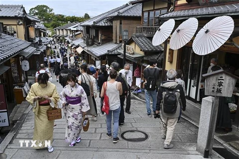 Du khách tham quan và mua sắm trên một con phố ở Kyoto, Nhật Bản. (Ảnh: AFP/TTXVN)