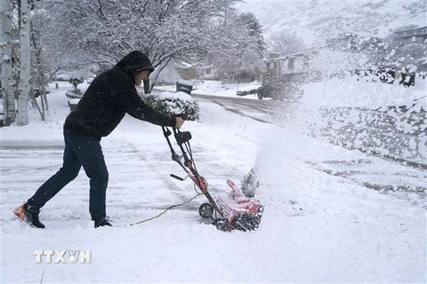 Người dân dọn tuyết trên đường phố tại Provo, Utah, Mỹ, ngày 13/12/2022. (Ảnh: AFP/TTXVN)