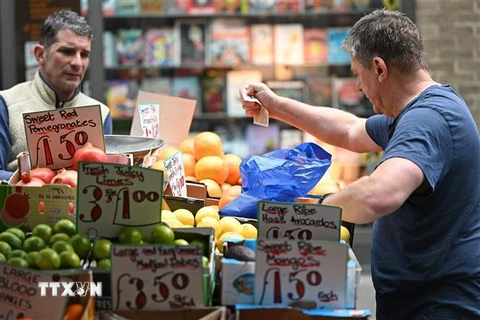 Người dân mua sắm tại một chợ ở London, Anh. (Ảnh: AFP/TTXVN)