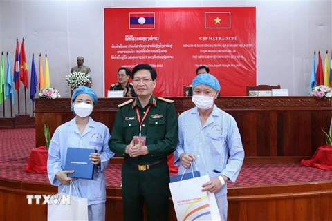 Thiếu tướng, Phó Giáo sư, Tiến sỹ Nguyễn Xuân Kiên, Giám đốc Bệnh viện 103 Việt Nam, tặng quà cho 2 bệnh nhân người Lào được ghép thận thành công. (Ảnh: Phạm Kiên-Bá Thành/TTXVN)