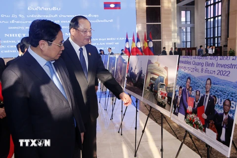 Thủ tướng Phạm Minh Chính và Thủ tướng Lào Sonexay Siphandone tham quan triển lãm. (Ảnh: Phạm Kiên/TTXVN)