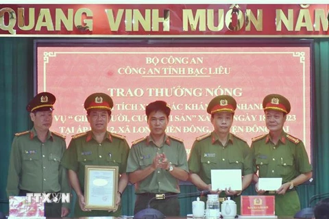 Đại tá Lê Việt Thắng, Giám đốc Công an tỉnh Bạc Liêu (đứng giữa), trao thưởng cho Ban chuyên án. (Ảnh: Hải Linh/TTXVN phát)