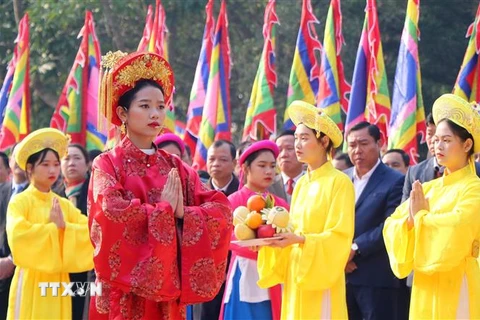Chủ tế nữ mặc bộ lễ phục mầu đỏ thực hiện nghi thức tế lễ truyền thống. (Ảnh: Trung Kiên/TTXVN)