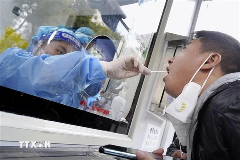 Nhân viên y tế lấy mẫu xét nghiệm COVID-19 cho người dân tại Bắc Kinh, Trung Quốc ngày 12/10/2022. (Ảnh: Kyodo/TTXVN)