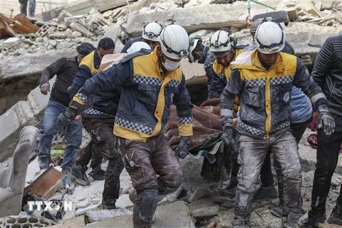 Lực lượng cứu hộ chuyển người bị thương ra khỏi đống đổ nát sau trận động đất tại Idlib, Syria ngày 7/2/2023. (Ảnh: AFP/TTXVN)