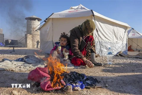 Người dân đốt lửa sưởi ấm trong thời tiết giá lạnh do bị mất nhà cửa sau trận động đất tại Jindayris, Syria, ngày 9/2/2023. (Ảnh: AFP/TTXVN) 