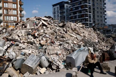 Một người đàn ông ngồi cạnh đống đổ nát sau trận động đất khủng khiếp ở Antakya, Thổ Nhĩ Kỳ. (Nguồn: Reuters)