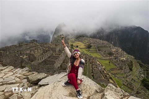 Khách du lịch chụp ảnh lưu niệm tại Thành cổ Machu Picchu thuộc tỉnh Cusco, Peru ngày 2/11/2020. (Ảnh: AFP/TTXVN)