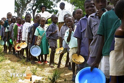 Trẻ em xếp hàng chờ nhận thực phẩm cứu trợ tại Harare, Zimbabwe. (Ảnh: AFP/TTXVN)