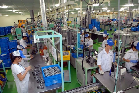 Công nhân làm việc tại dây chuyền sản xuất linh kiện ôtô, xe máy tại Khu công nghiệp Thăng Long. (Ảnh: Danh Lam/TTXVN) 