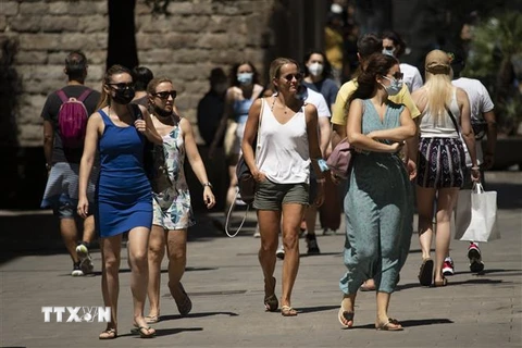 Người dân di chuyển trên phố ở Barcelona, Tây Ban Nha. (Ảnh: AFP/TTXVN)