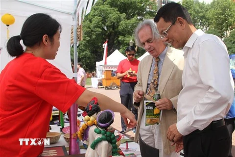 Đại sứ Việt Nam tại Argentina và Thứ trưởng Ngoại giao nước chủ nhà Pablo Tettamanti thăm gian hàng Việt Nam tại hội chợ. (Ảnh: Ngọc Tùng/TTXVN)