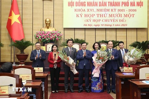 Bí thư Thành ủy Hà Nội Đinh Tiến Dũng và lãnh đạo thành phố chúc mừng bà Vũ Thu Hà và một số cá nhân vừa được bầu giữ cương vị mới. (Ảnh: TTXVN)
