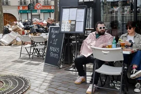 Đống rác khổng lồ phía trước một nhà hàng ở Paris hôm 25/3. (Nguồn: Getty Images)