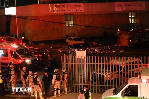 Cảnh sát và lính cứu hỏa được triển khai tại hiện trường vụ hỏa hoạn ở tòa nhà Viện Di cư quốc gia thuộc thành phố Ciudad Juarez, bang Chihuahua, Mexico tối 27/3/2023. (Ảnh: AFP/TTXVN)