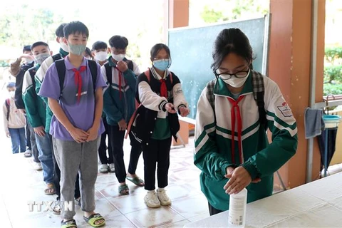 Học sinh trường Trung học cơ sở thị trấn Khánh Yên rửa tay sát khuẩn trước khi vào lớp. (Ảnh: Quốc Khánh/TTXVN)