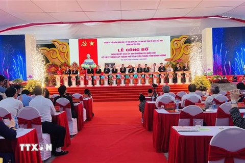 Các lãnh đạo cao cấp Trung ương và địa phương nhấn nút công bố thành lập thành phố Tân Uyên thuộc tỉnh Bình Dương. (Ảnh: Huyền Trang/TTXVN)