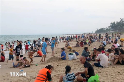 Bãi biển Đồi Dương (thành phố Phan Thiết) đông người dân và du khách trong ngày nghỉ lễ đầu tiên. (Ảnh: Nguyễn Thanh/TTXVN)