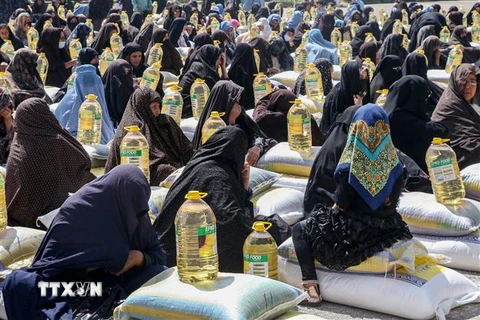 Người dân nhận thực phẩm cứu trợ tại Herat, Afghanistan, ngày 11/4/2023. (Ảnh: AFP/TTXVN)