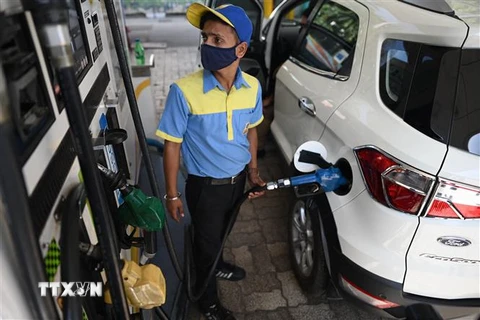 Nhân viên bơm xăng cho phương tiện tại trạm xăng ở New Delhi, Ấn Độ. (Ảnh: AFP/TTXVN)