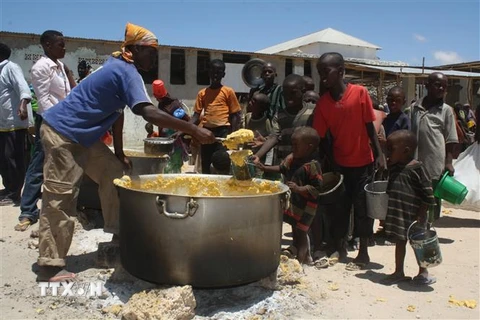 Trẻ em nhận bữa ăn từ thiện tại Howlwadag, phía Nam thủ đô Mogadishu, Somalia. (Ảnh: AFP/TTXVN)