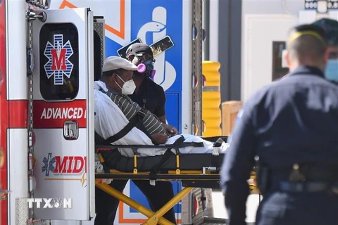 Nhân viên y tế chuyển bệnh nhân COVID-19 tới trung tâm y tế ở New York, Mỹ. (Ảnh: AFP/TTXVN)