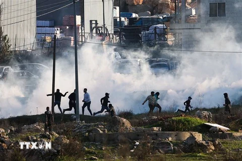 Lực lượng an ninh Israel bắn hơi cay về phía người biểu tình Palestine trong cuộc đụng độ tại thành phố Ramallah, khu Bờ Tây, ngày 26/1/2023. (Ảnh: AFP/TTXVN)