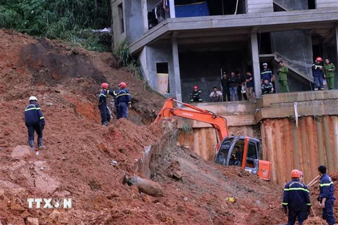 Lực lượng cứu hộ sử dụng máy múc để tìm kiếm người mất tích tại hiện trường vụ sạt lở. (Ảnh: Chu Quốc Hùng/TTXVN)