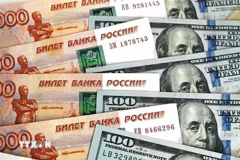Đồng ruble (bên trái) và đồng USD (bên phải). (Ảnh: Sputnik/TTXVN)