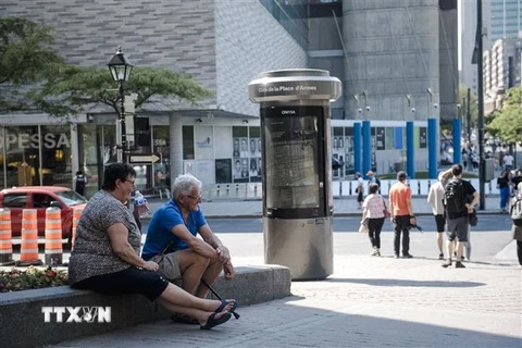 Người dân tránh nắng dưới bóng râm tại Montreal, Quebec, Canada, ngày 1/6/2023. (Ảnh: AFP/TTXVN)
