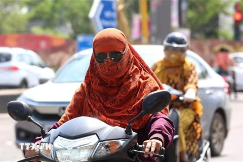Người dân mặc áo chống nắng bảo vệ dưới thời tiết nắng nóng gay gắt tại Bhopal, bang Madhya Pradesh, Ấn Độ, ngày 6/7/2023. (Ảnh: THX/TTXVN)