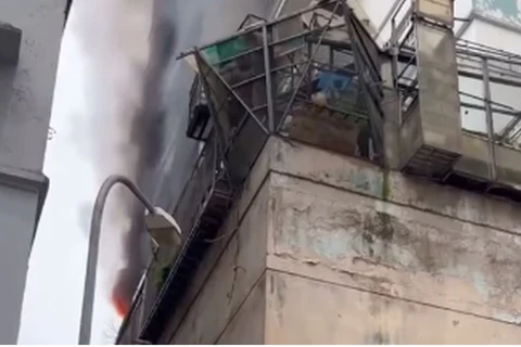 Khói bốc lên từ đám cháy tại Tòa nhà 262 Nguyễn Huy Tưởng, phường Thanh Xuân Trung. (Nguồn: VTV)