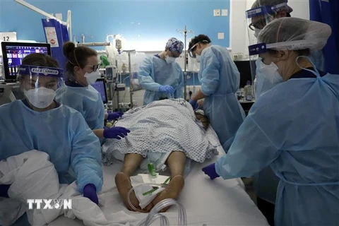 Nhân viên y tế điều trị cho bệnh nhân COVID-19 tại bệnh viện ở London, Anh. (Ảnh: AFP/TTXVN)