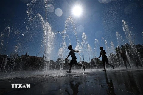 Trẻ em làm mát tại đài phun nước ở Colmar, miền Đông Pháp ngày 21/8/2023. (Ảnh: AFP/TTXVN)
