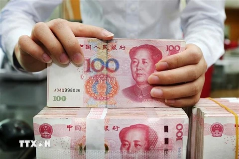 Nhân viên kiểm đồng 100 Nhân dân tệ tại ngân hàng ở tỉnh Giang Tô, Trung Quốc. (Ảnh: AFP/TTXVN)