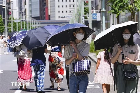 Người dân che ô tránh nắng nóng tại Tokyo, Nhật Bản, ngày 16/7/2023. (Ảnh: Kyodo/TTXVN)