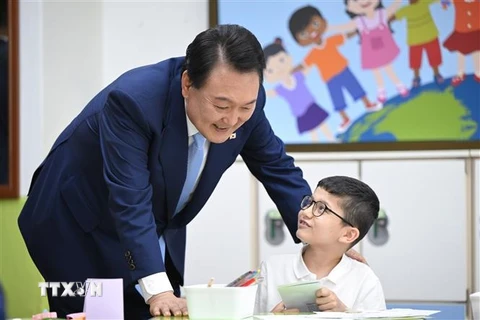 Tổng thống Hàn Quốc Yoon Suk Yeol (trái) thăm Trường Tiểu học Suwon, cách thủ đô Seoul 30km về phía Nam, ngày 3/7/2023. (Ảnh: Yonhap/TTXVN)