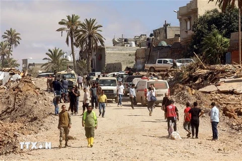 Người dân di dời khỏi khu vực đổ nát do lũ quét, gây ra bởi cơn bão Daniel, ở thành phố miền Đông Derna, Libya ngày 14/9/2023. (Ảnh: AFP/TTXVN)